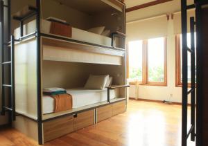 a room with bunk beds in a room with a window at Nyaman Hostel in Canggu +18 photos
