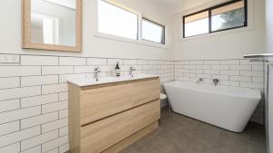 Un baño con bañera, lavabo e inodoro. en Classic 70's Beach House Outside - 97-99 Lohr Avenue, en Inverloch 6 fotos más