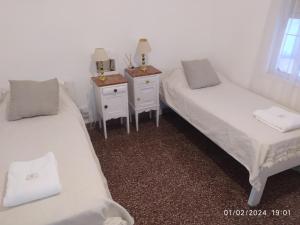 a room with two beds and two night stands at La casa in Gualeguaychú