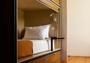 a bed in a room with a mirror at Nyaman Hostel in Canggu