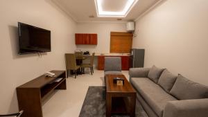 a living room with a couch and a table at Hadiqat Lina Serviced Apartments Al Khobar in Al Khobar