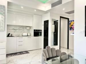 a kitchen with white cabinets and a glass table at Gray D'Albion -2A8- 1 Chambre in Cannes