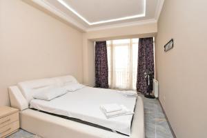 une chambre blanche avec un lit et une fenêtre dans l'établissement Rent Inn Yerevan on Buzand Street, à Erevan