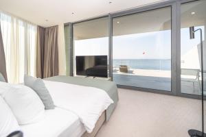 a bedroom with a bed and a view of the ocean at Sea Star Budva in Budva