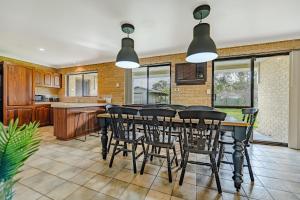 a kitchen and dining room with a table and chairs at The Vintage Beach House in Dawesville