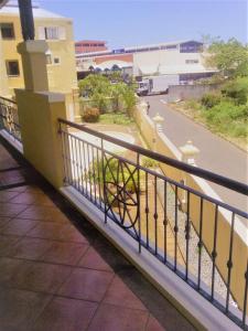 a balcony with a fence and a street at Lovely 1 bedroom apartment in Grand Bay, around 5 mins walk to the beach in Grand Baie