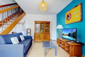a living room with a blue couch and a tv at Ylang Ylang - apt T3 la Saline les Bains in Saint-Paul