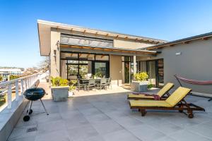 クニスナにあるSunny Double Volume Penthouse, All Ensuiteの家の上にハンモック付きのパティオ
