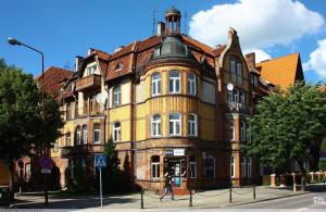 a woman walking in front of a large building at Mazurski klimat in Ełk