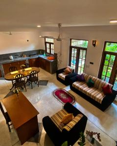 Una sala de estar con sofás y una mesa y una cocina. en Jasmine villa - Mihiripenna, en Talpe