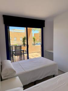 1 dormitorio con 2 camas y vistas a un patio en Darwins Luxury Mojácar, en Mojácar