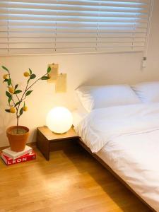 Un dormitorio con dos camas y una planta en maceta. en Aju stay Geoje, en Geoje 42 fotos más