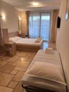 a room with two beds in it with a window at Lux By Kaliakria in Topola +24 photos