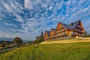 ビャウカにあるRezydencja Słoneczna - SPA & Apartamenty z widokiem - Białka Tatrzańskaの草の丘の上の大家