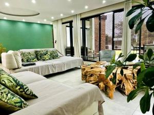 a living room with two couches and a green wall at Sublima Villa, Luxe et élégance in La Gaulette +192 photos