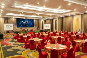 a conference room with tables and chairs and a stage at Aston Gorontalo Hotel & Villas in Gorontalo