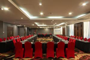 a conference room with red chairs and a large table at Aston Gorontalo Hotel & Convention Center in Gorontalo +48 photos