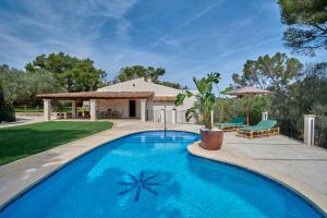 a swimming pool in front of a house at Finca Ses Rotes in Cala Ferrera