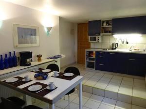 a kitchen with a table and chairs and a kitchen with a counter at Alte Schule Bollersen in Bergen