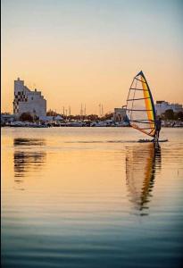 osoba na plaży z żaglem w wodzie w obiekcie Le Dimore di Donato w mieście Torre San Giovanni Ugento +10 zdjęć