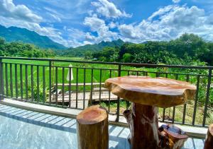 a table on a balcony with a view of mountains at Meadow Mai Chau Homestay in Mai Chau +35 photos