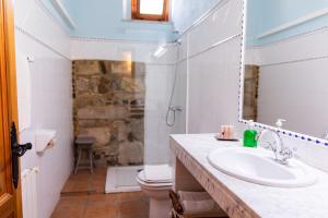 Un baño con lavabo, inodoro y espejo. en Agroturisme Sant Dionis, en Campllong