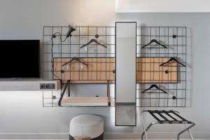 a room with a tv and a shelf with hangers at Moxy La Ciotat in La Ciotat