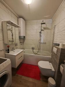 a bathroom with a toilet and a tub and a sink at Apartment Liora in Osijek