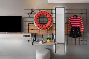 a room with a tv and a mirror and a shelf at Moxy La Ciotat in La Ciotat