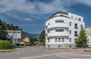 un edificio blanco con una parte superior redonda en una calle en Rezidencia Galéria, en Ružomberok