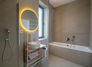 Un baño con lavabo, bañera y espejo. en Rezidencia Galéria, en Ružomberok 21 fotos más