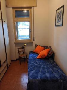 Un dormitorio pequeño con una cama y una ventana. en Casa di Bepi, en Udine