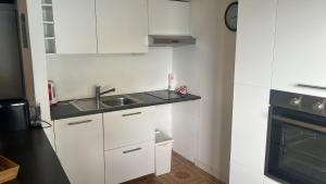 a kitchen with white cabinets and a sink and a stove at Dream Apartment Room lake 3 in Paradiso +10 photos