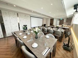 a conference room with tables and chairs and a screen at Calligraphy Greenway Hotel in Taichung +82 photos