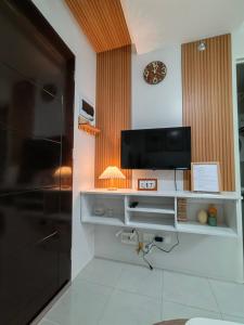 Elle comprend un salon avec une télévision et un réfrigérateur. dans l'établissement 2 bedroom condo, à Mandaue City
