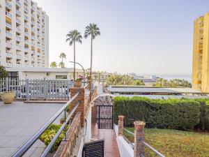 a balcony with a fence and palm trees at Cubo's Beach Side Diana Apartment in Benalmadena Costa