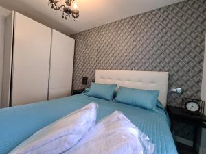 una camera da letto con un letto grande con cuscini blu di Dos Torres Ribera Play & Relax con Jacuzzi y cine a Saragozza Altre 10 foto