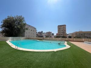 a large swimming pool in a field of grass at Apartamento 1ª Línea de Playa - Con Piscina y Parking in Playa de Gandia