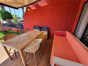 a wooden table and chairs and a table and a bench at Vivienda Vacacional frente al mar Playa del Aguila in Playa del Aguila