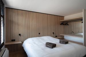 a bedroom with a white bed with two rocks on it at Au Coin Quatorze in Poperinge +31 photos