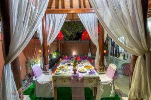 a table in a room with white drapes at Private Pool Villas in Kuta