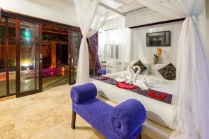 a bedroom with a bed and a purple chair at Private Pool Villas in Kuta
