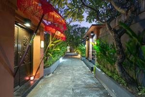 a walkway with a red umbrella on a building at Private Pool Villas in Kuta