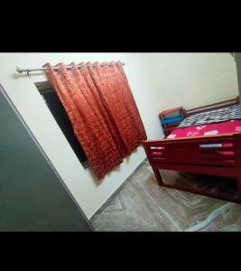 a red curtain hanging on a wall next to a bed at Divya Homestay in Udupi