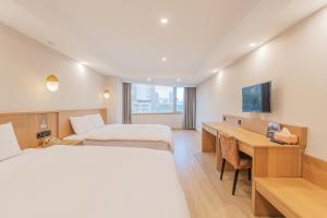 a hotel room with two beds and a desk at Hamilton Hotel in Taichung