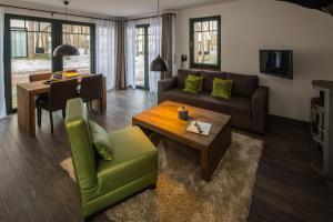 ein Wohnzimmer mit Sofa und Tisch in der Unterkunft Van der Valk Naturresort Drewitz in Nossentiner Hütte