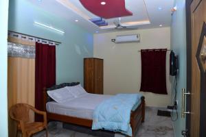 a small bedroom with a bed and a television at jkpalace in Yelagiri