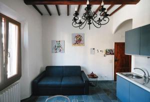 a living room with a blue couch in a kitchen at Casa del borgo antico in Poggibonsi