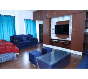 a living room with a couch and a tv at Hotel Omkaar & Restaurant Chinyalisaur in Chhām