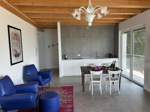 a kitchen and dining room with blue chairs and a table at Pai 521 openspace in Torri del Benaco
